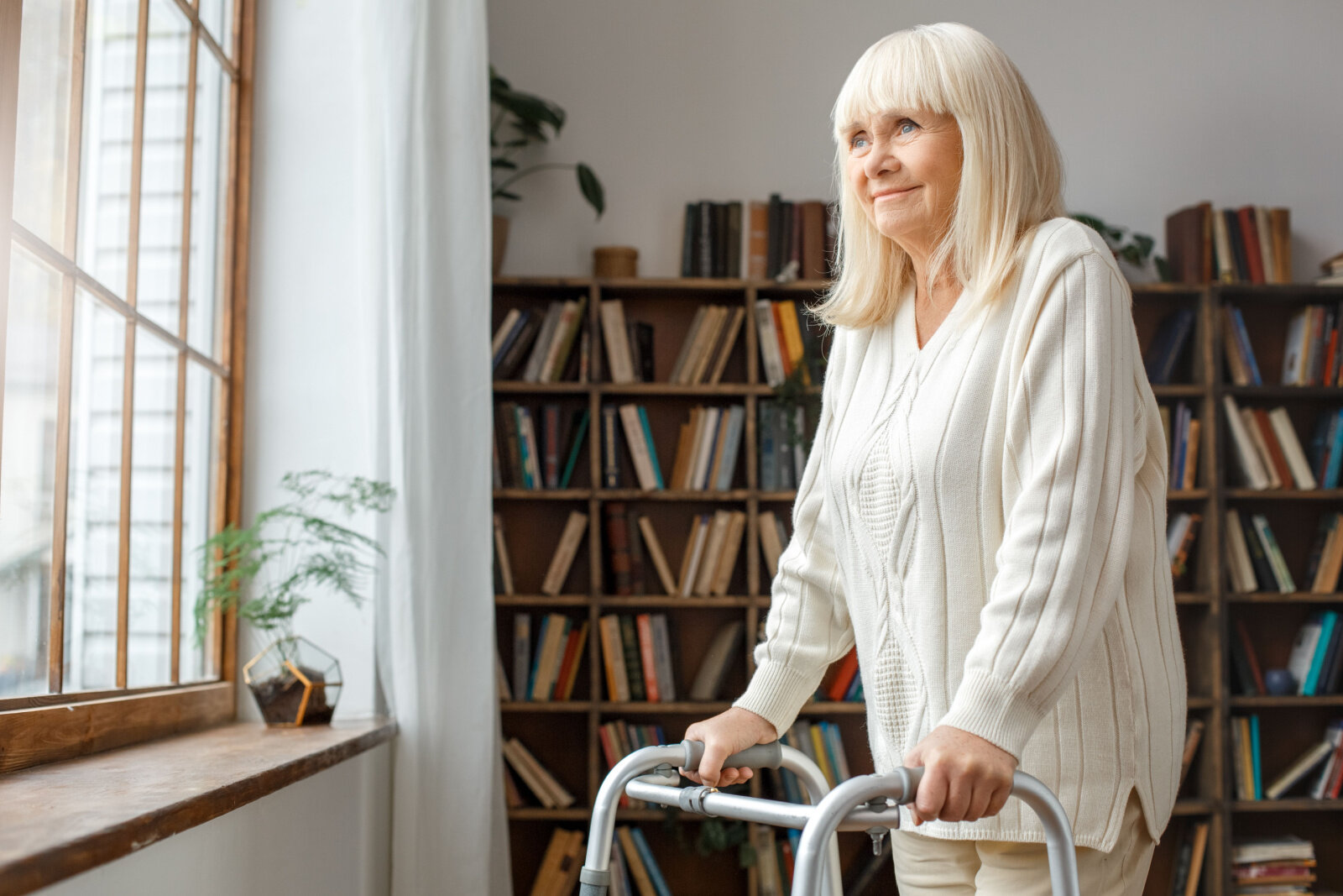Woman with folding walker looking in a window.