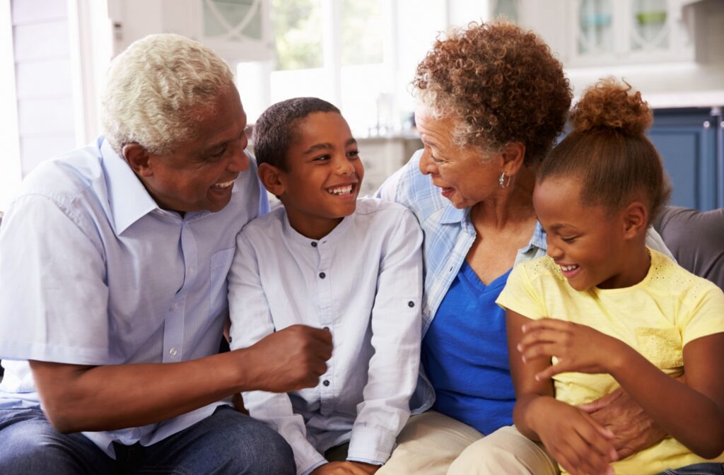 Senior couple laughing while spending time with their young grandchildren.