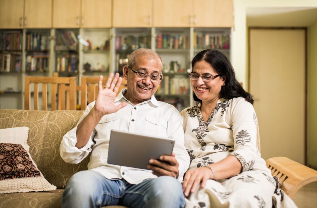 A senior couple greets family over video call when a physical visit to their assisted living home can’t be done
